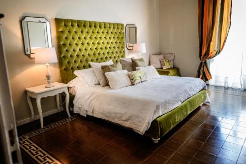a bedroom with a large bed with a yellow headboard at B&B Palazzo Cerami in Catania