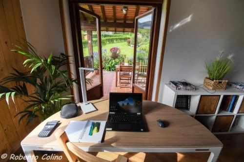 a desk with a laptop computer on top of it at Artesoro Baserria in San Pedro de Galdames
