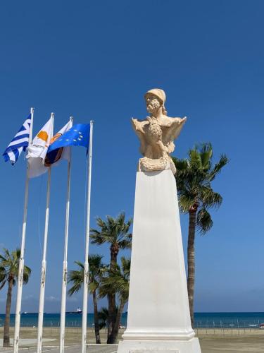 a statue on the beach next to some flags at Alex Beach Apartment 203 in Larnaka