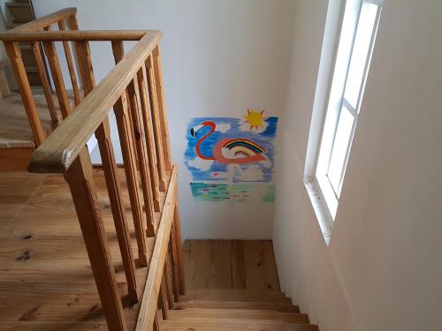 a staircase with a painting of a bird on the wall at Villa Villekulla in Grigoleti