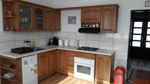 uma cozinha com armários de madeira e um frigorífico branco em Rodinný dom u Veroniky em Snina
