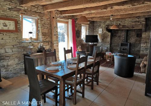 Pleyben的住宿－Coeur du Finistère，一间带木桌和椅子的用餐室