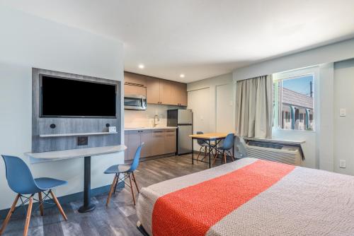 a hotel room with a bed and a flat screen tv at Solo Motel Broadway in Los Angeles
