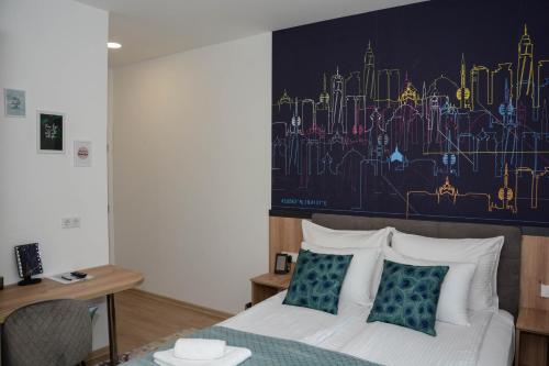 a bedroom with a bed with a painting on the wall at OLYMPIC 84 Apartments in Sarajevo