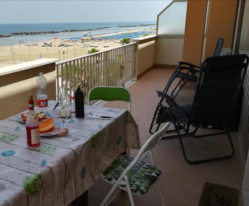 einen Tisch und Stühle mit Blick auf den Strand in der Unterkunft Appartamento Alba Rosa in Francavilla al Mare