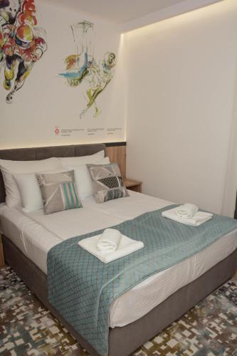 a bedroom with a bed with two towels on it at OLYMPIC 84 Apartments in Sarajevo