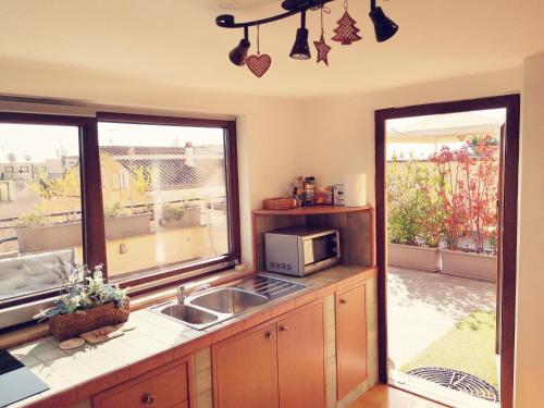 a kitchen with a sink and a microwave at SUPERATTICO SUL COLOSSEO in Rome