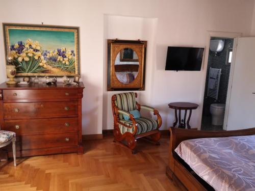a bedroom with a dresser and a bed and a chair at SUPERATTICO SUL COLOSSEO in Rome