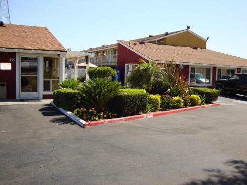 a parking lot in front of a building with plants at Oasis Inn Sacramento- Elk Grove in Sacramento
