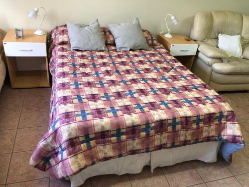 een bed in een kamer met 2 tafels en een bank bij A un paso de todo !!! Lo de Richard in Ushuaia