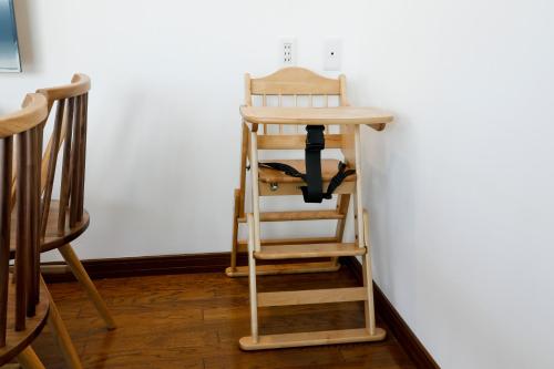 a wooden high chair sitting next to a wall at 釜之宿 天王寺 in Osaka
