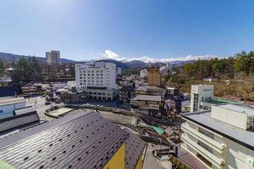 an aerial view of a city with mountains in the background at Daitokan in Kusatsu