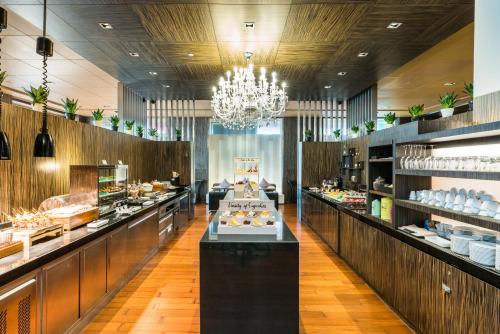 a restaurant with a buffet line with a chandelier at Pathumwan Princess Hotel - SHA Extra Plus Certified in Bangkok