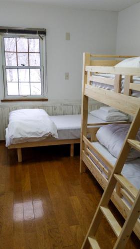 a room with two bunk beds and a window at Chalet Banff - 6 bedroom 6 bathroom Ski Lodge in Niseko