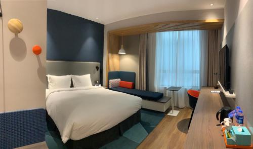 Tempat tidur dalam kamar di Holiday Inn Express Shanghai Kangqiao, an IHG Hotel