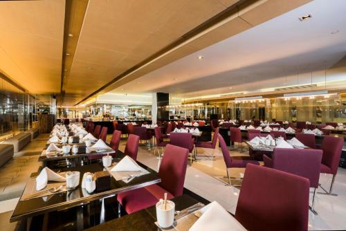a dining room with tables and purple chairs at Pathumwan Princess Hotel - SHA Extra Plus Certified in Bangkok