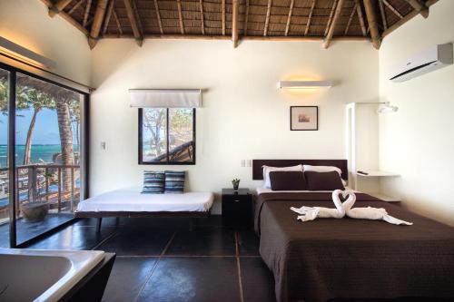 a bedroom with two beds and a tub and a sink at Hangin Kite Resort in Boracay