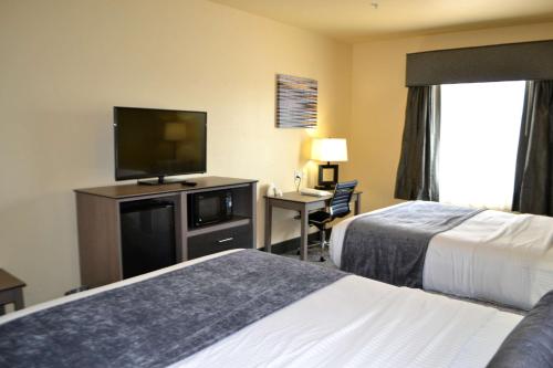 um quarto de hotel com duas camas e uma televisão de ecrã plano em Best Western Sherwood Inn & Suites em North Little Rock