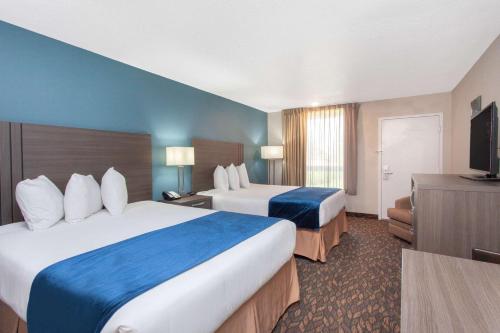 a hotel room with two beds and a television at Grand Hotel Orlando at Universal Blvd - Shuttle to Theme Parks in Orlando