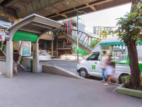 a white van parked at a gas station with people walking by at ibis Styles Bangkok Sukhumvit Phra Khanong in Bangkok
