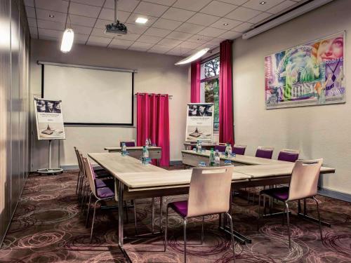 una sala de conferencias con mesas, sillas y una pizarra en Mercure Lyon Charbonnières, en Charbonnières-les-Bains