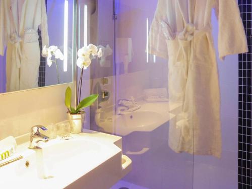 a bathroom with a sink and a shower at Mercure Brive in Ussac