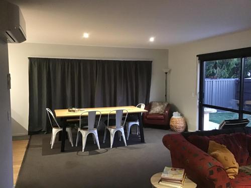 a living room with a table and chairs and a couch at Cromwell Retreat in Cromwell