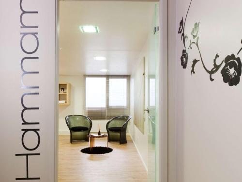 - un couloir avec deux chaises et une table dans une chambre dans l'établissement ibis Styles Lorient Caudan, à Caudan