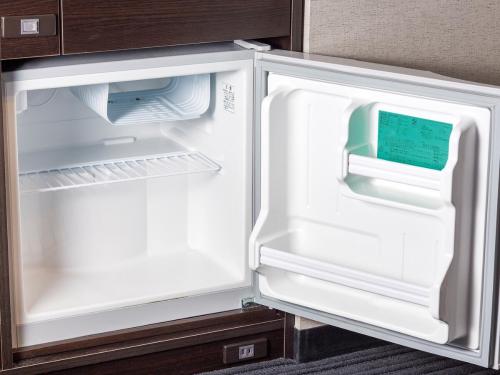 an empty refrigerator with its door open in a kitchen at APA Hotel Nihombashi Bakuroyokoyama Ekimae in Tokyo