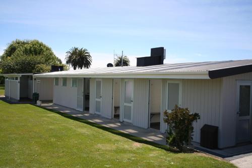 a row of modular buildings on a lawn at Levin TOP 10 Holiday Park in Levin