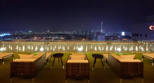 a rooftop patio with tables and chairs at night at Shilla Stay Samsung COEX Center in Seoul