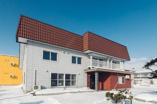 a house with a red roof in the snow at stay in 末広 asahikawa in Nagayamachō