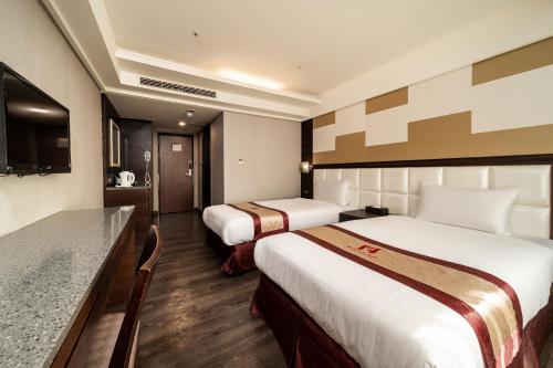 a hotel room with two beds and a counter at Fish Hotel Taitung in Taitung City