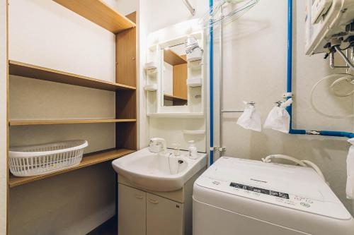La petite salle de bains est pourvue d'un lavabo et d'un lave-linge. dans l'établissement STAY IN PASSION, à Asahikawa