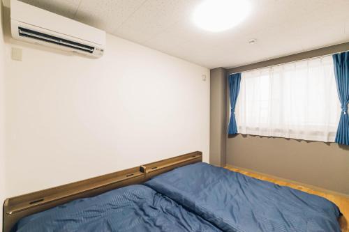 a bedroom with a bed and a window at STAY IN PASSION in Asahikawa