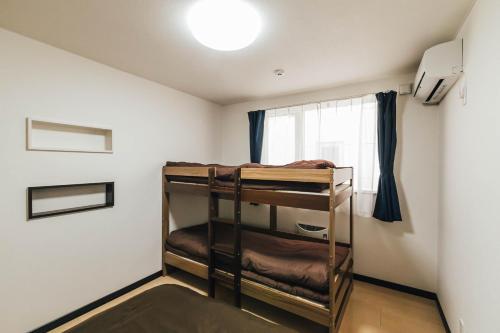 旭川市にあるSTAY IN ASAHIBASHI 旭川の窓付きの二段ベッドが備わる客室です。