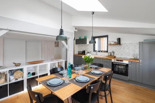 - une cuisine avec une table et des chaises en bois dans la chambre dans l'établissement Villa Emeraude by Cocoonr, à Saint-Briac-sur-Mer