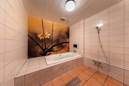 La salle de bains est pourvue d'une baignoire et d'une peinture murale. dans l'établissement Hotel & Spa Lotus (Adult Only), à Kyoto