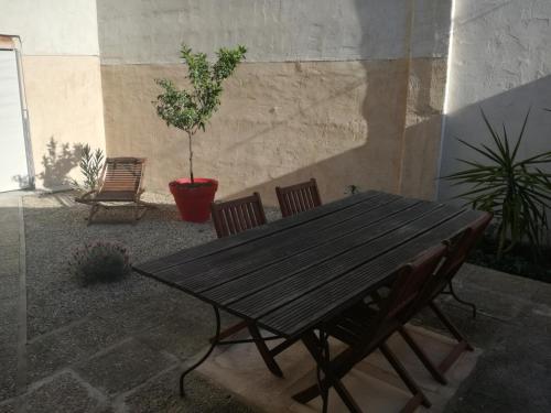 アルルにあるappartement villa Marie Fannyの木製テーブル(椅子2脚付)と鉢植え