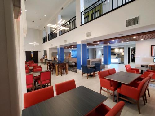 a restaurant with red chairs and tables and tablesktop at Holiday Inn Express & Suites Phoenix Glendale Dist by IHG in Glendale