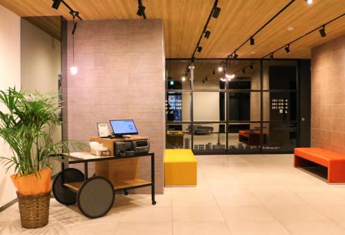 a lobby with a table with a laptop on it at M's Hotel Sanjo Omiya in Kyoto