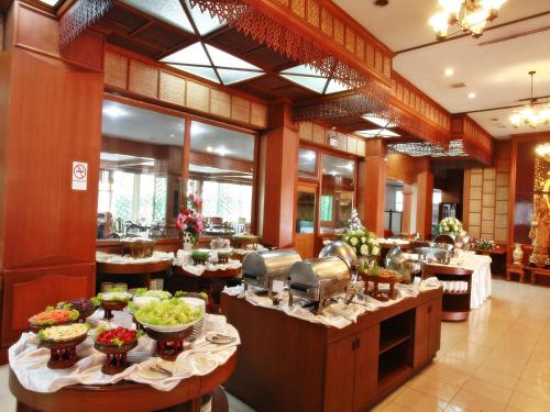 ein Restaurant mit Tischen und Essen darauf in der Unterkunft Chiang Mai Phucome Hotel in Chiang Mai