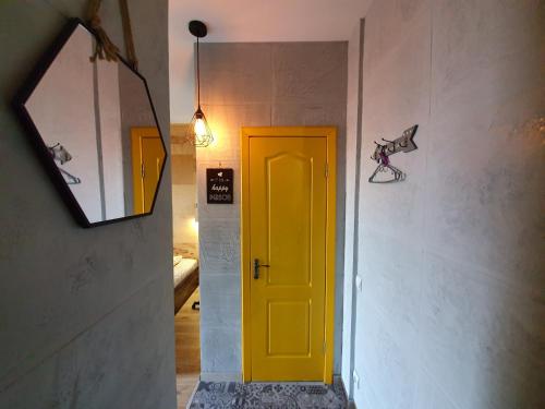 eine gelbe Tür im Flur mit Spiegel in der Unterkunft Посуточно апартаменты Ивано-Франковск 602 in Iwano-Frankiwsk