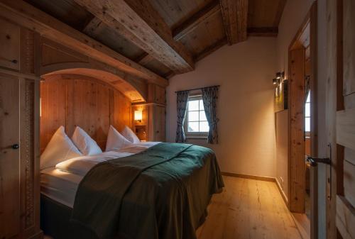 ein Schlafzimmer mit einem großen Bett in einem Zimmer mit Holzdecken in der Unterkunft Chalet Berghof Sertig in Clavadel