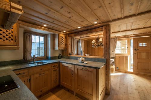 eine Küche mit Holzschränken und einer Holzdecke in der Unterkunft Chalet Berghof Sertig in Clavadel