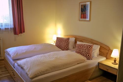 1 dormitorio con 1 cama con 2 almohadas en Appartementhaus Habich, en Bad Kleinkirchheim