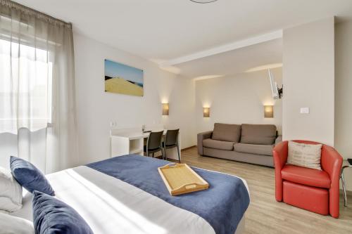 ペサックにあるAll Suites Appart Hôtel Bordeaux Pessacのベッドとソファ付きのホテルルーム