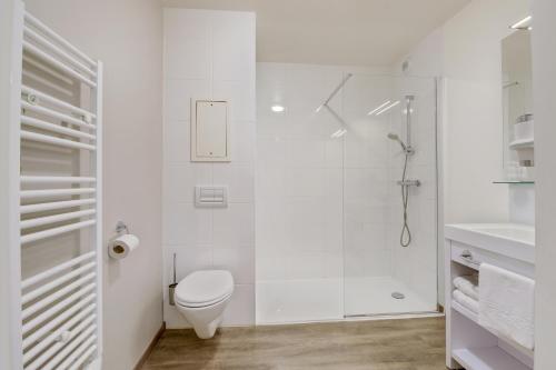 a white bathroom with a toilet and a shower at All Suites Appart Hôtel - Bordeaux - Pessac in Pessac