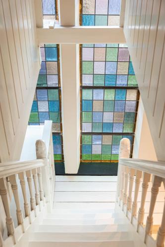 a staircase with a stained glass window at Church conversion for a unique stay and experience in Rinsumageest