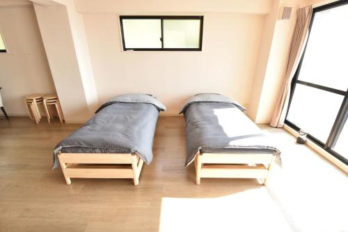Habitación amplia con 2 camas y ventanas. en Enzo Uno, en Tamano